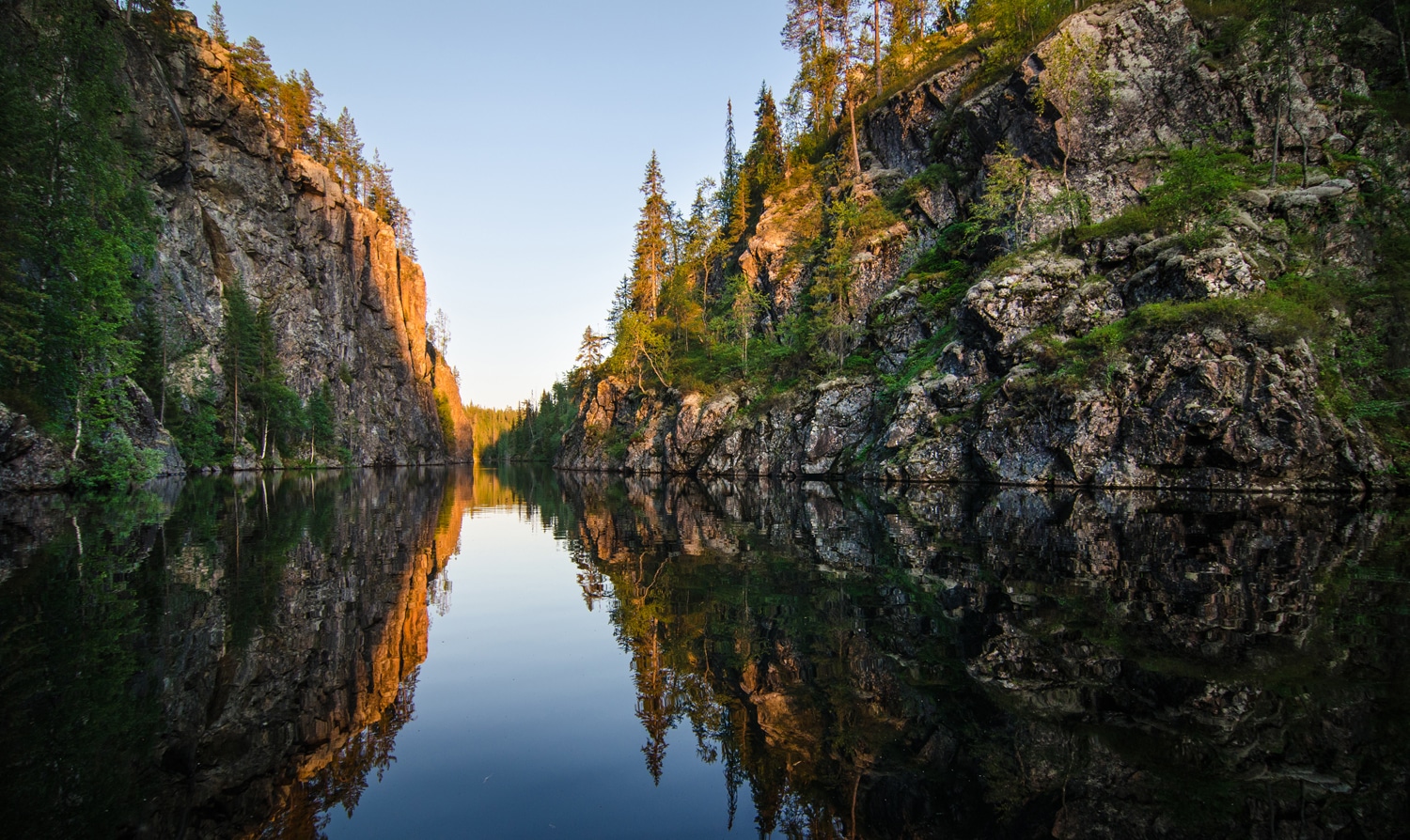 Kanjonijärvi iltaauringossa, kanjonijärven kapein kohta on noin 10 metriä ja kallioseinämillä harvakseltaan puita.