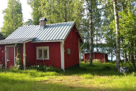 Punainen mökki, joka sijaitsee Hietajärven rannalla.