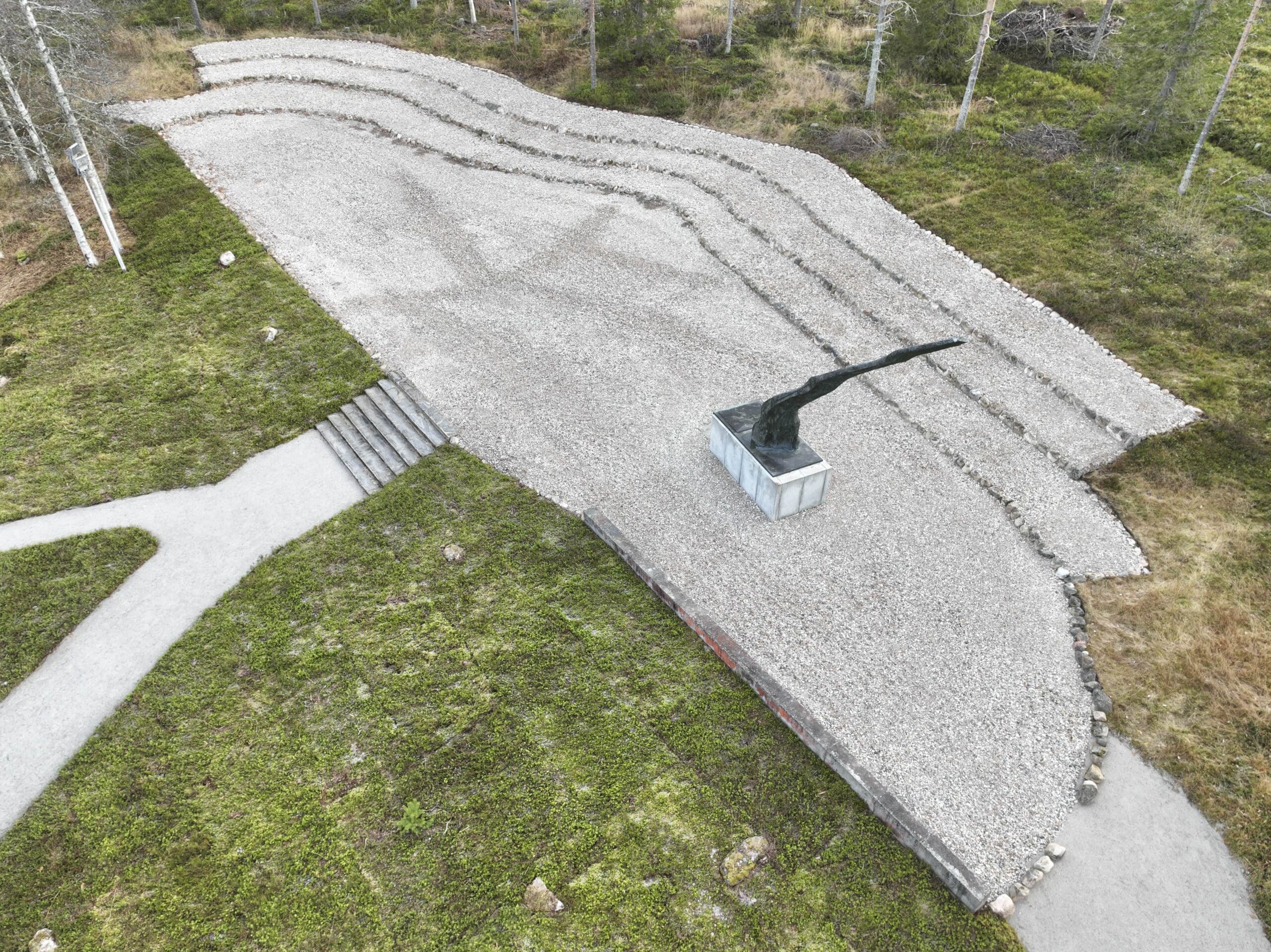 Alvar Aallon suunnittelema Liekkipatsas kohoaa yläviistoon ja sitä ympäröi sorastettu puoliympyrän muotoinen alue.