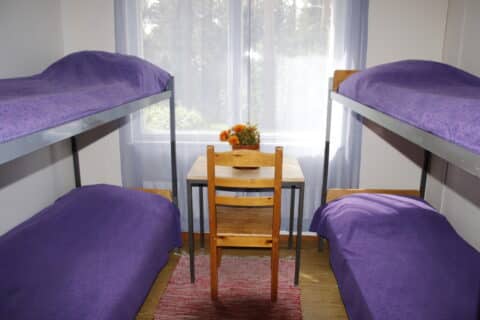 Raatteen koulun huoneissa on kerrossängyt sekä pieni kirjoituspöytä.