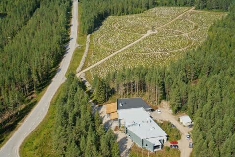 Ilmakuva Raatteen Portin museoalueesta, etualalla harmaa museorakennus ja taustalla Talvisodan monumentin kivikenttä, vasemmalla kulkee Raatteentie.