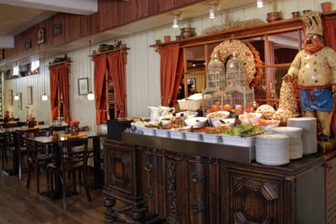 Kuvassa ravintola Kultaisen Kukon salaattibuffet sekä pöytiä ja tuoleja.
