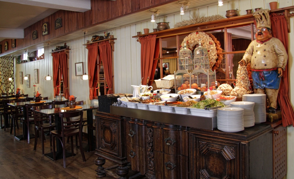 Kuvassa ravintola Kultaisen Kukon salaattibuffet sekä pöytiä ja tuoleja.