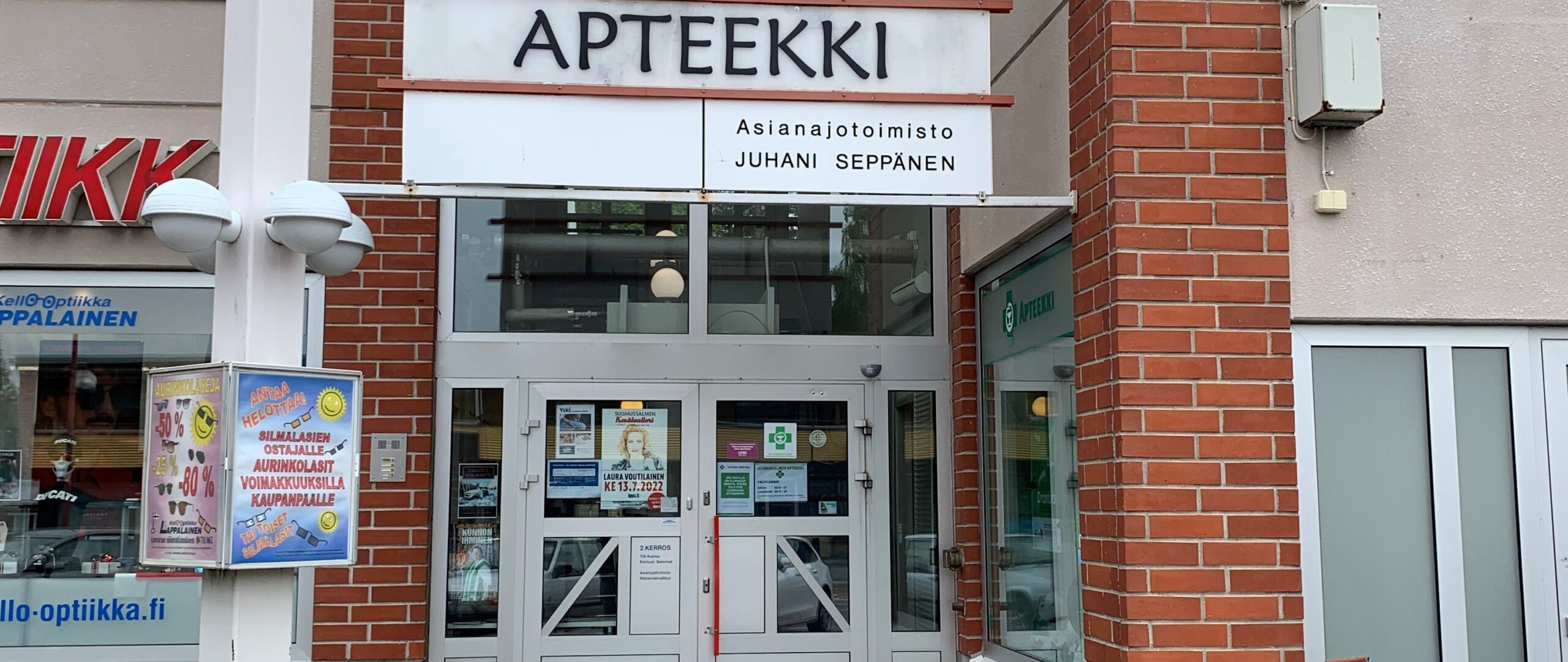 Apteekin ulko-ovi, jonka yläpuolella kylttejä.