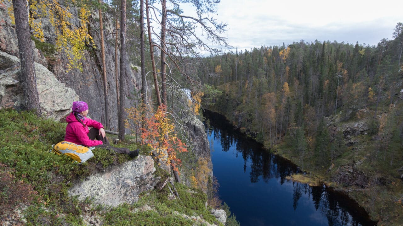 Hossa Nainen istuu Julma-Ölkyn kalliolla syksyisessä säässä.