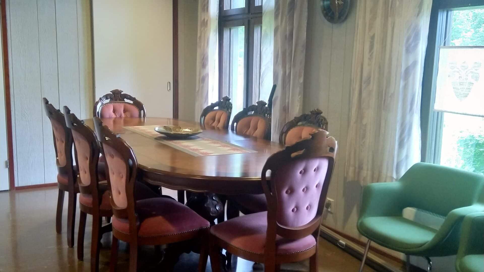 Pehmustetut tuolit ja pöytä Villa Anmaran oleskelutiloissa