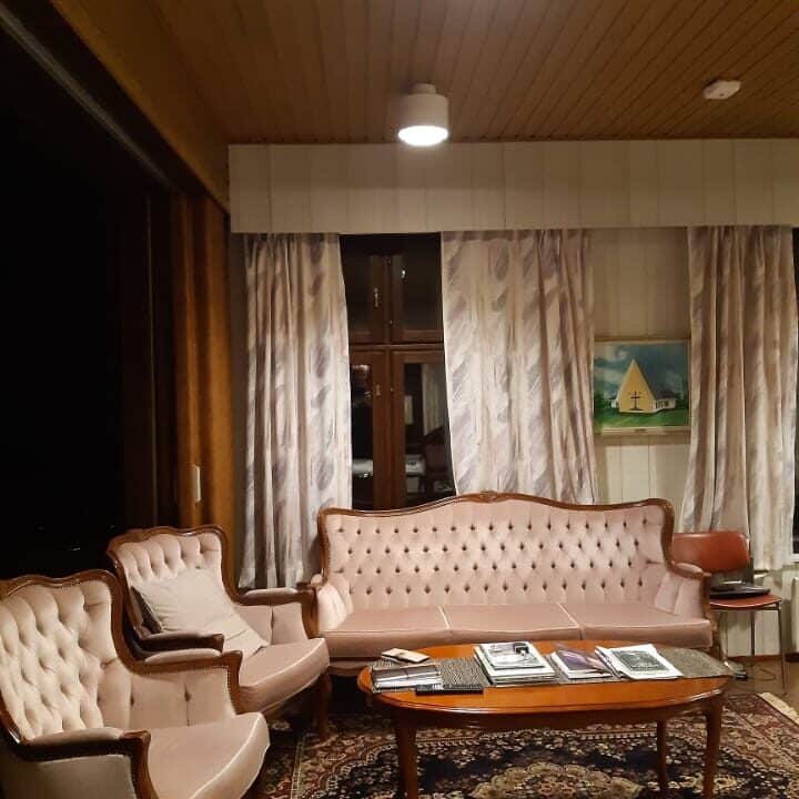 Olohuoneessa rokokoo tyylinen sohva, kaksi nojatuolia ja pöytä.