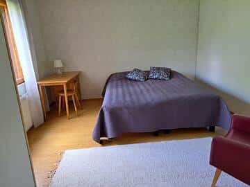 Makuuhuoneessa parisänky sekä tuoli ja pöytä.