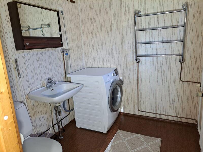 WC:.sä lavuaari, peilikaappi, pyykinpesukone ja vaatteiden kuivauspatteri.
