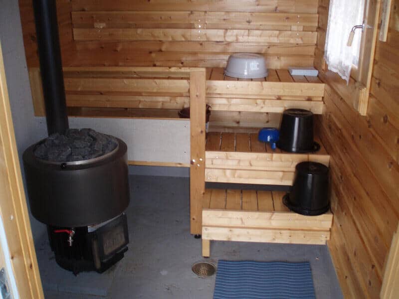 Kellokanervan saunan puiset lauteet ja muuripata.